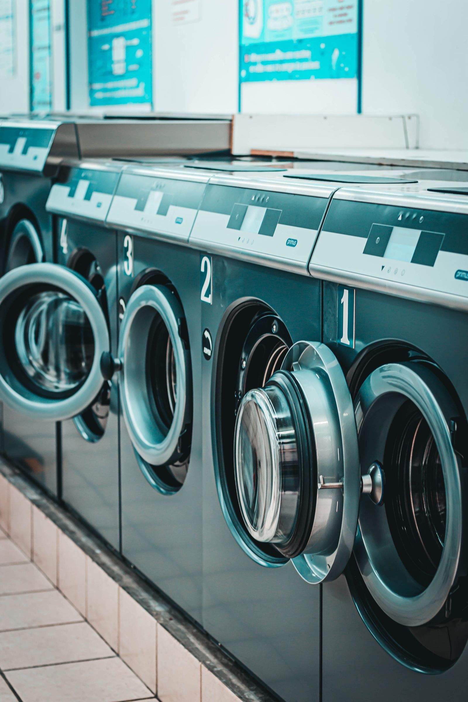 Row of compact washing machines in a small apartment laundry space