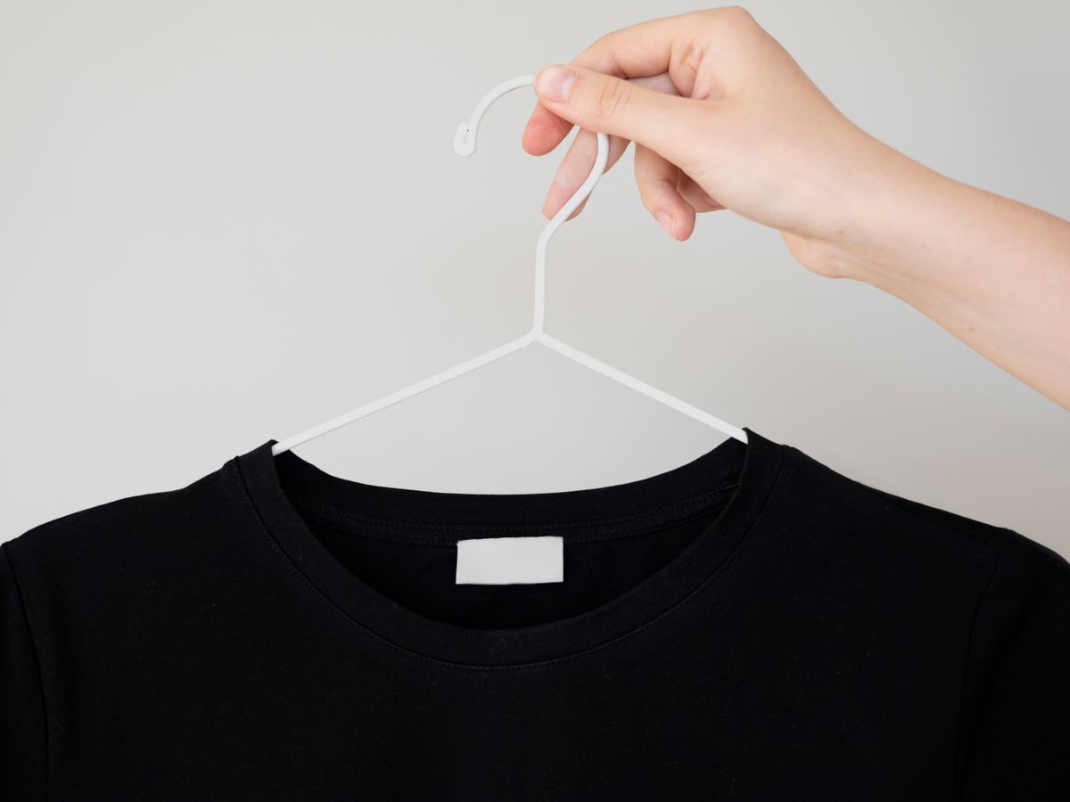 A hand holding a black t-shirt to keep black clothes from fading
