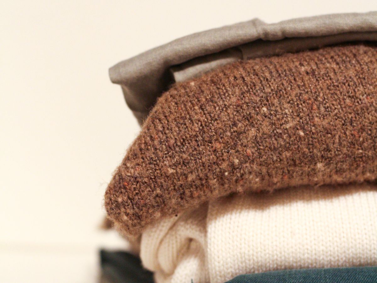 Capsule laundry routine with a neatly folded stack of sweaters