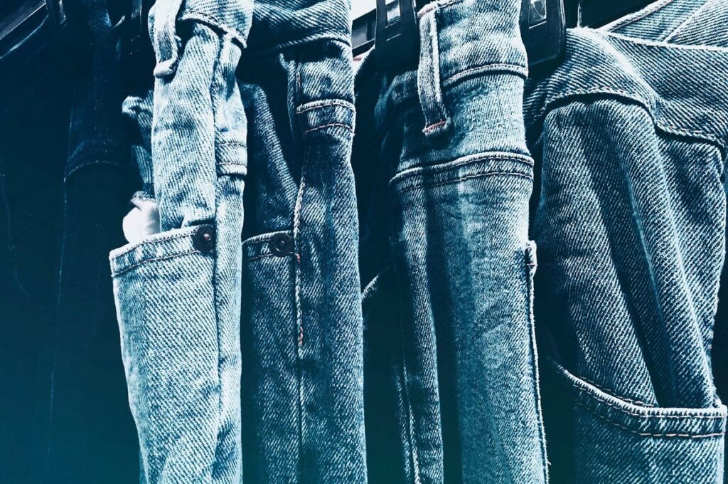 Blue jeans laid side by side showing how to care for denim