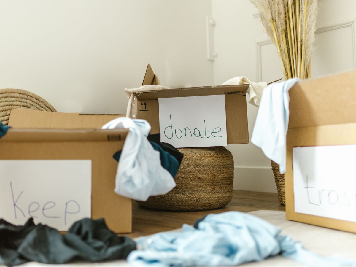 Boxes labeled keep, donate, and trash for a closet declutter