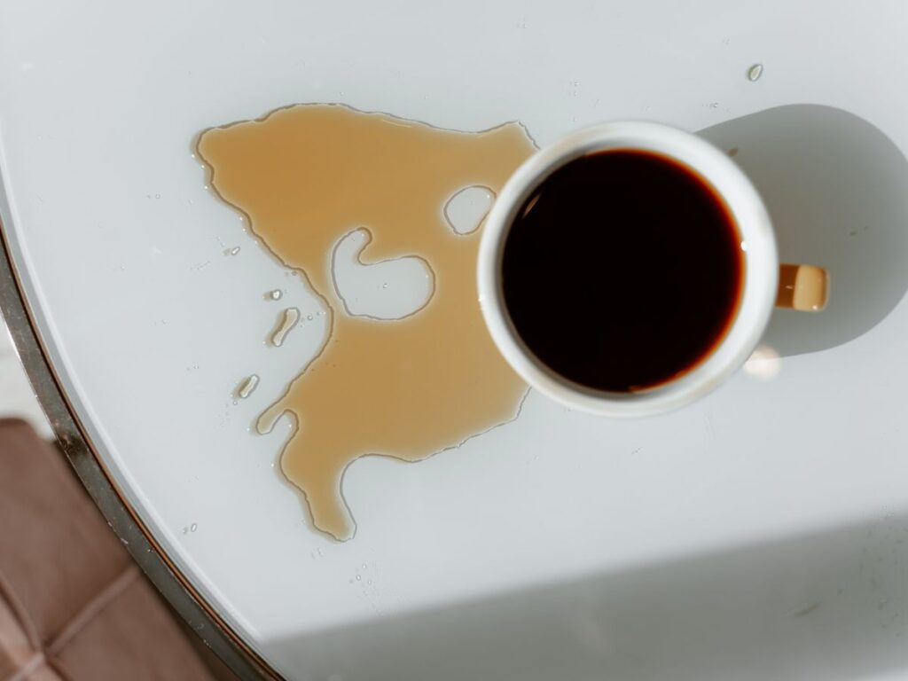 Overhead view of a coffee cup and spill representing a coffee stain