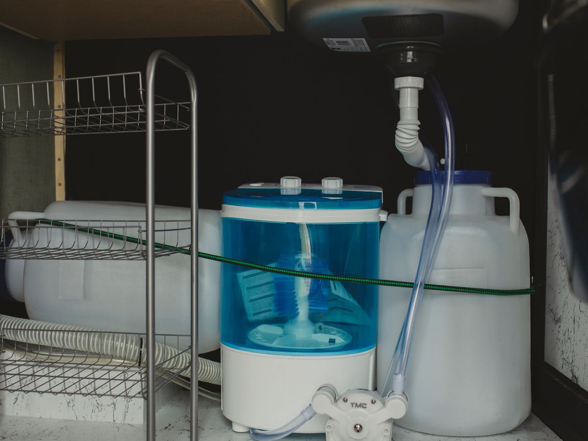 Compact washer stored in a tight laundry corner small apartment space
