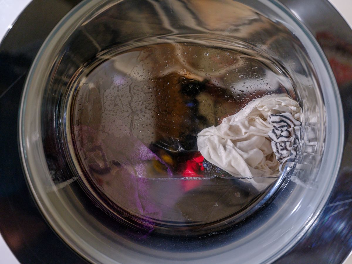 Clothes tumbling gently inside a front-loading washer on a delicate cycle