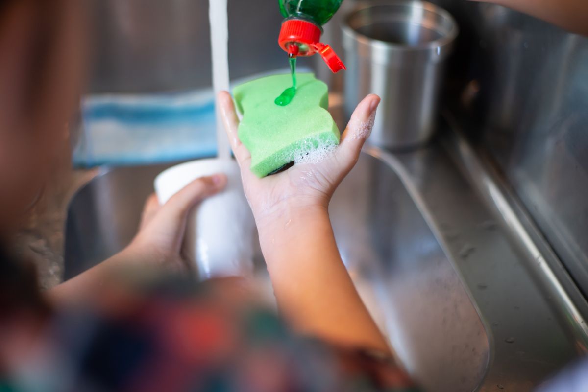 Applying dish soap to remove grease and oil stains from fabric