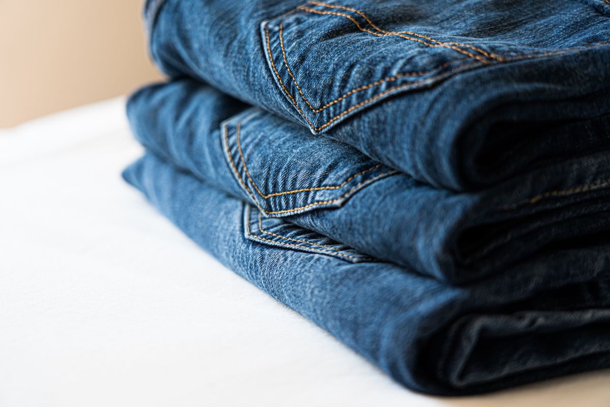A stack of neatly folded blue denim jeans that need washing only every ten wears
