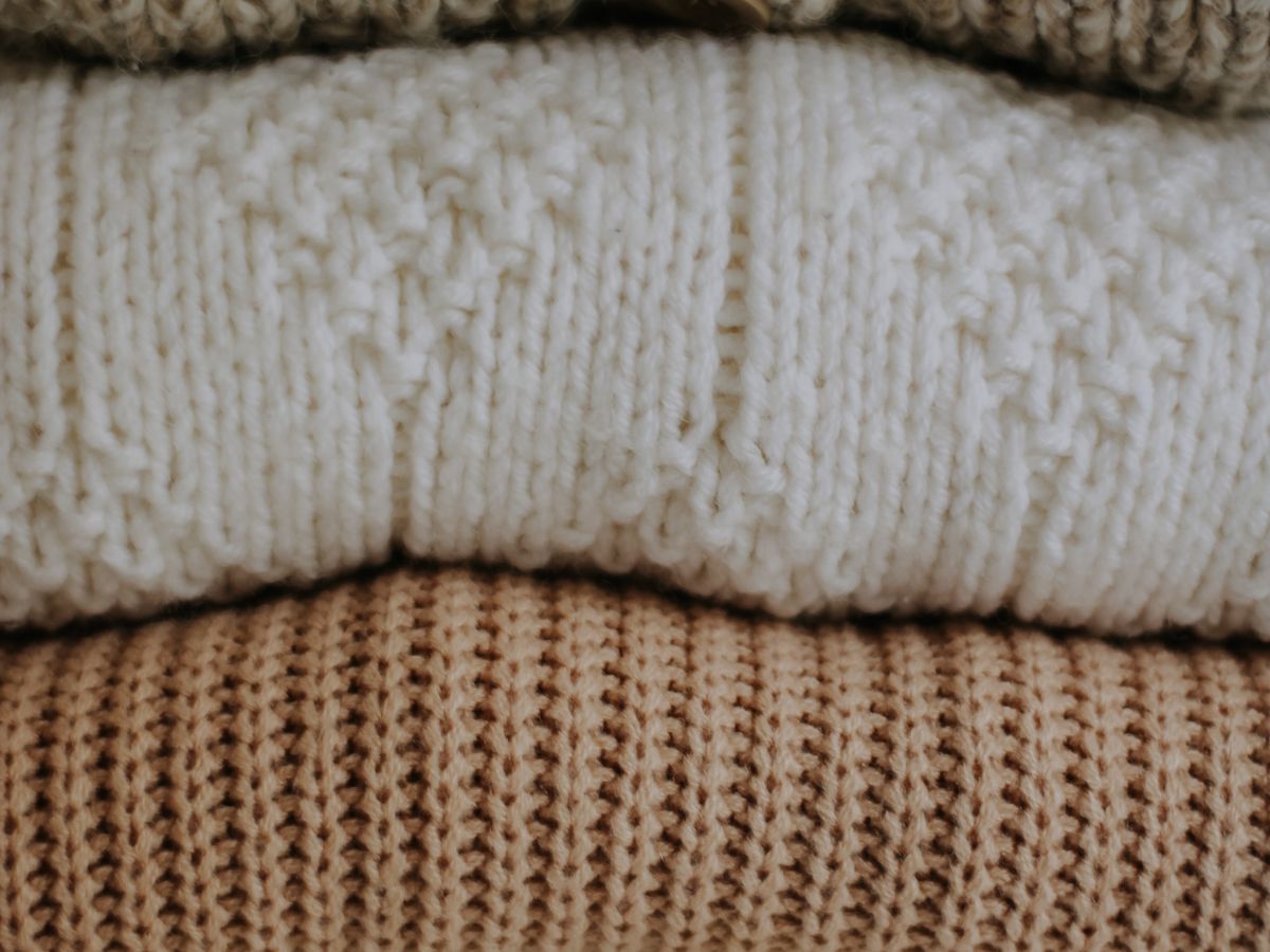 Knit sweaters laid flat to dry in a small apartment