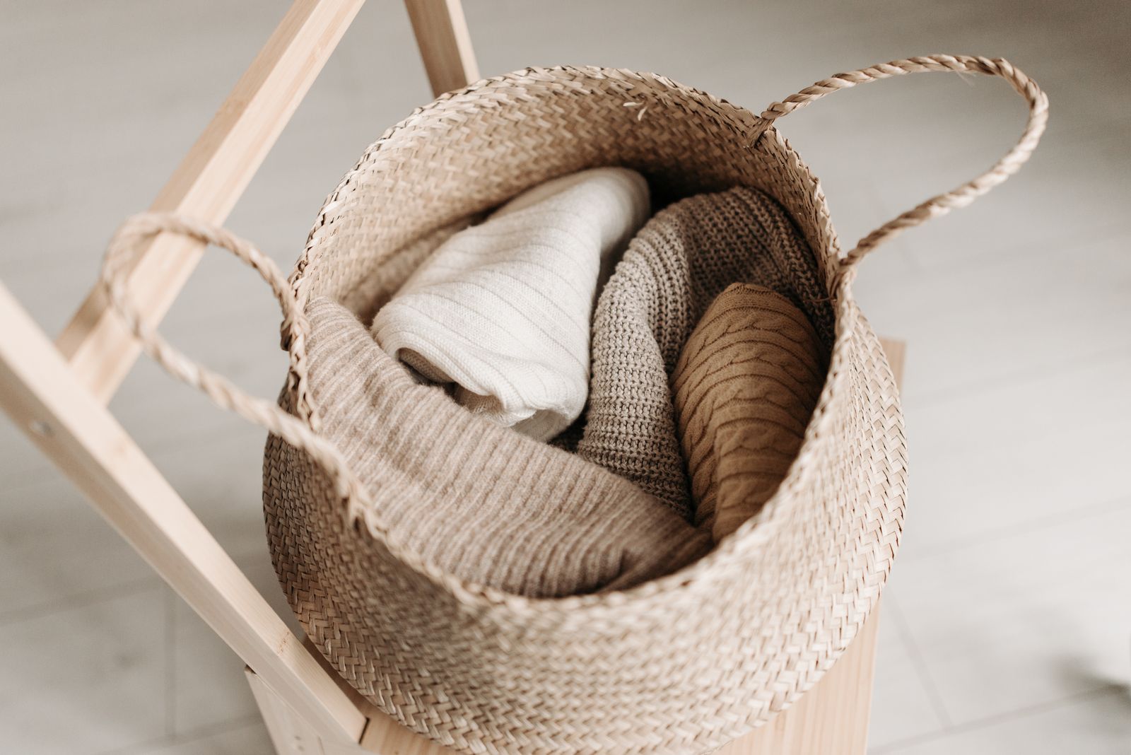 Folded knitted garments stored fresh in a woven basket
