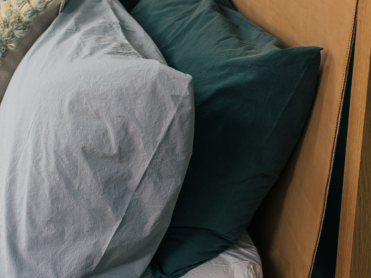 Freshly washed and fluffed pillows on a made bed