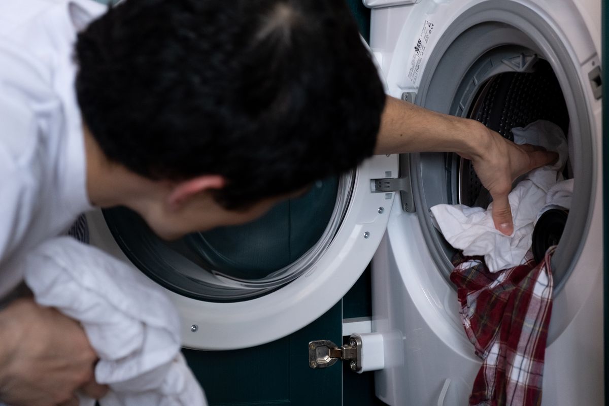 Placing clothes into a washing machine before adding a mild detergent