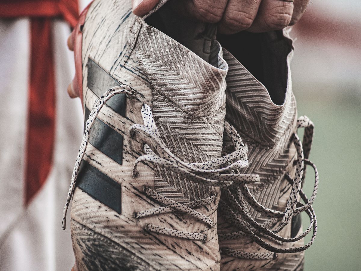 Worn soccer cleats covered in grass and dirt from active play