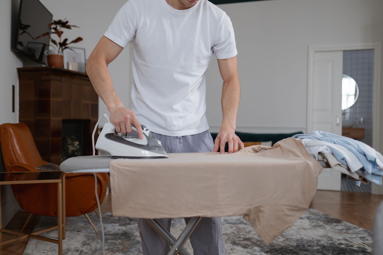 Person pressing a shirt on an ironing board using proper technique