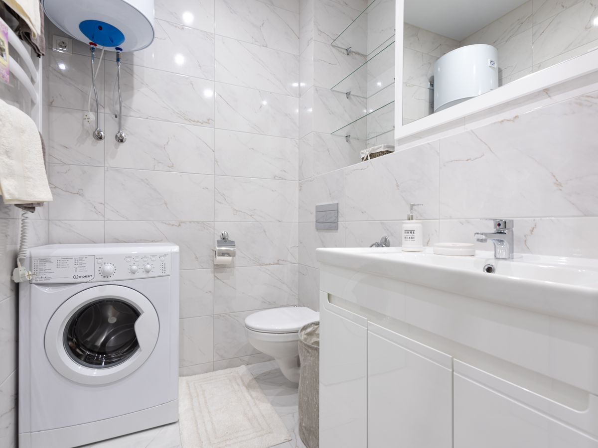 A laundry corner small apartment setup with a compact washing machine