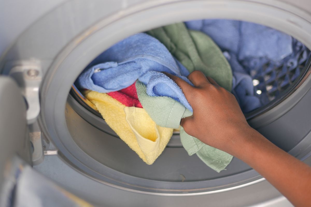 Loading clothes into the washing machine after treating grease and oil stains