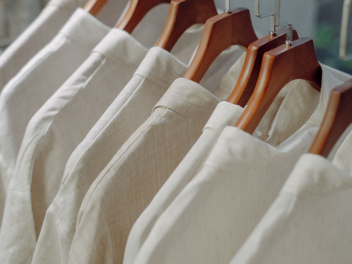 Neatly hung white shirts on wooden hangers keeping their shape