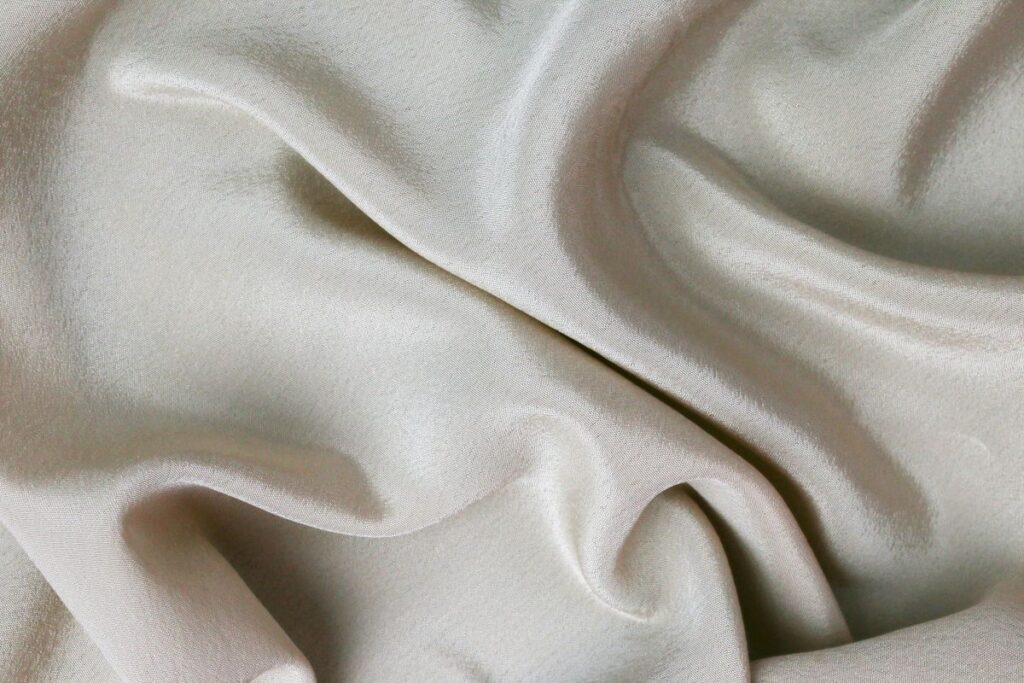 Silk care basics: smooth rippled cream silk fabric showing its delicate sheen