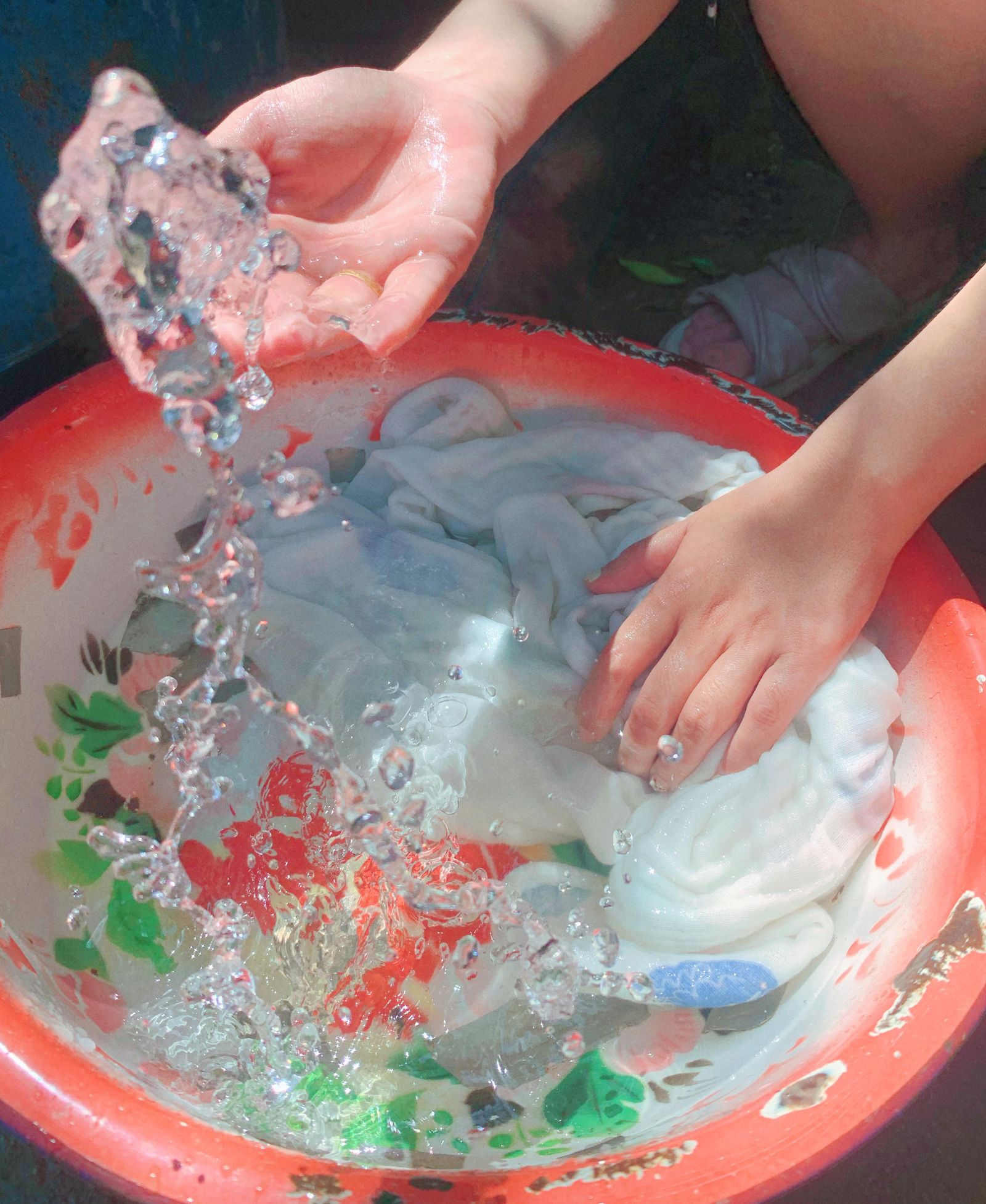 Soaking stained clothing in a basin to loosen dried blood