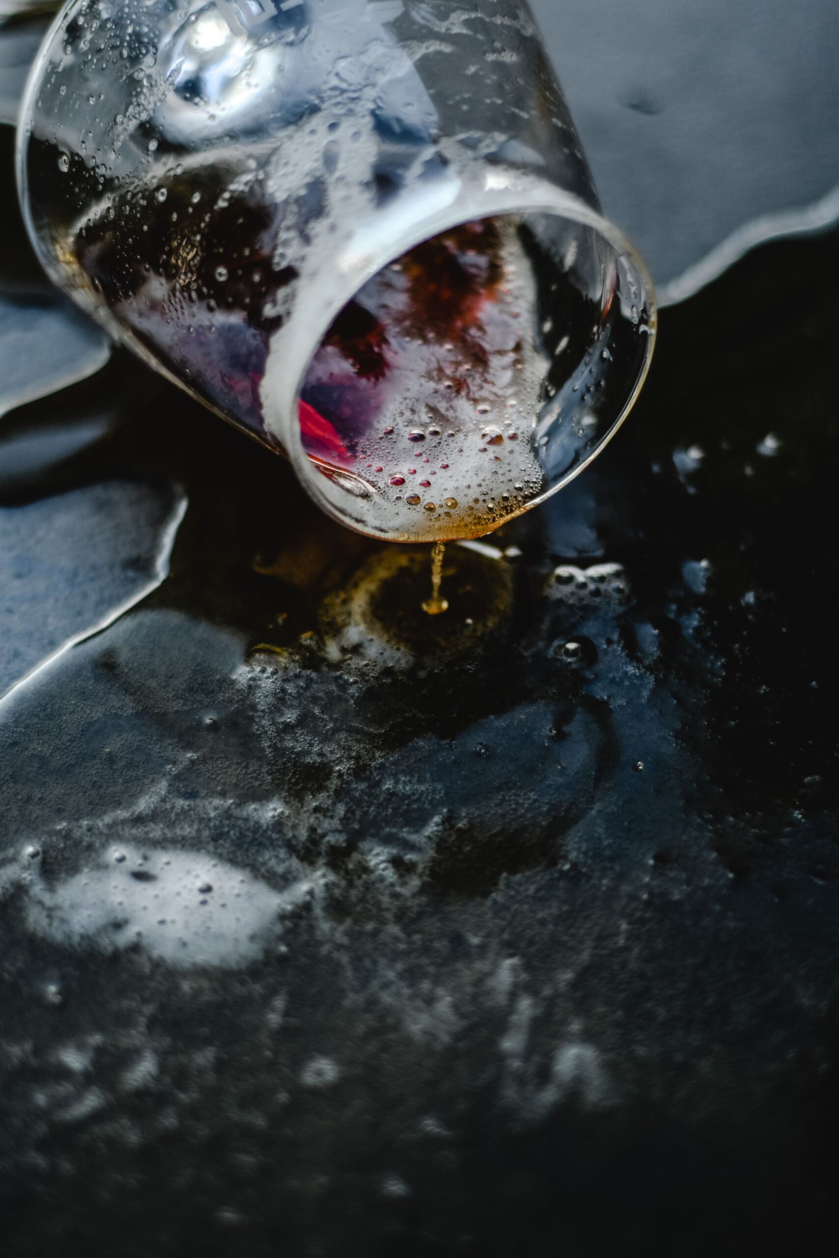 Soaking a stained garment in a basin of cool water to lift a dried red wine stain