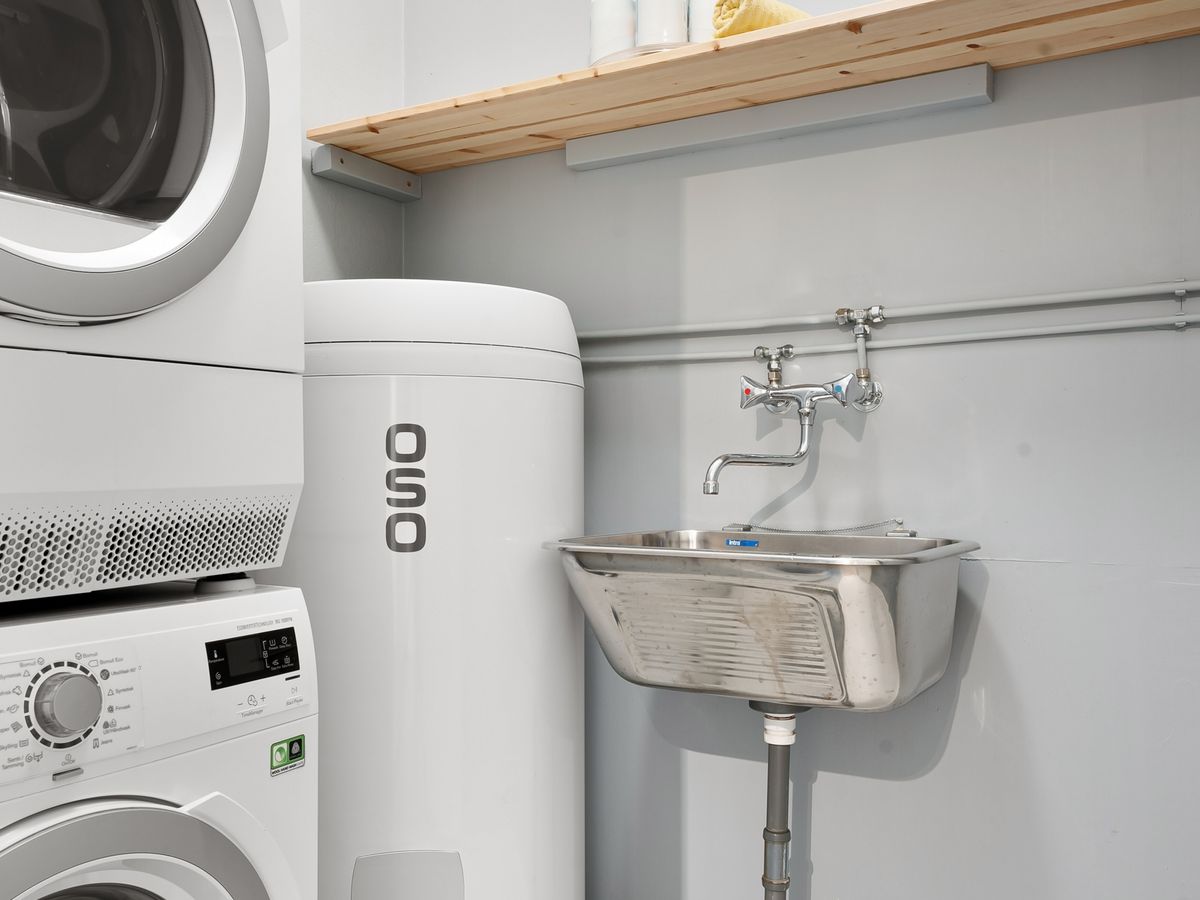 A tidy organized laundry space with a sink in a small apartment