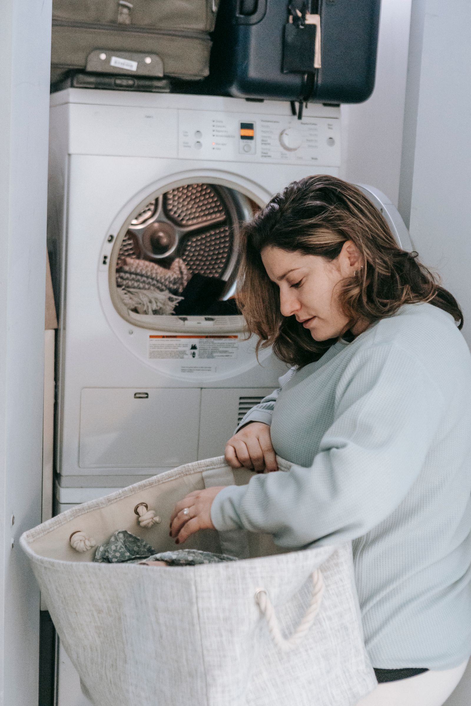 Woman using a portable washing machine at home in a small apartment