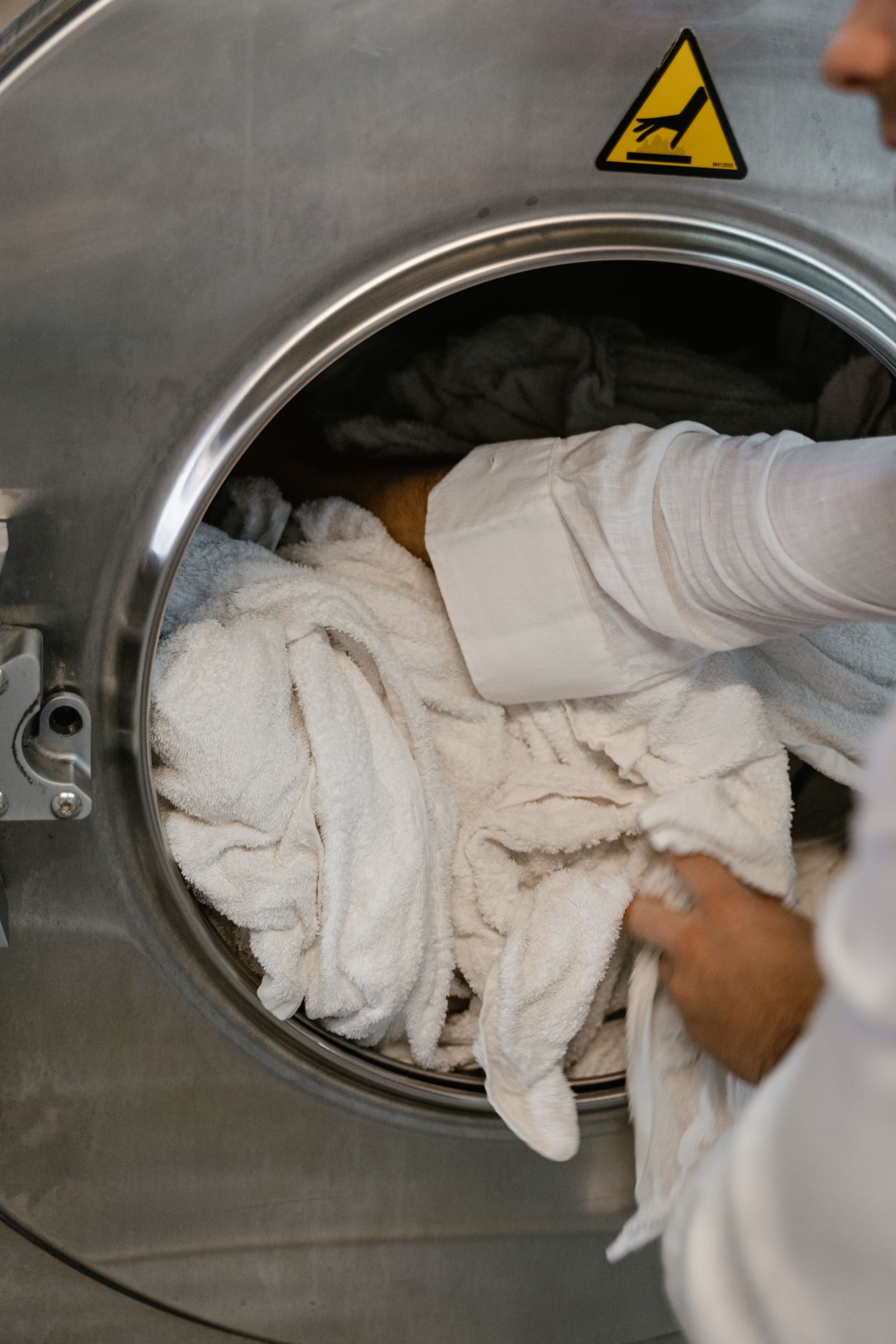Loading clean white laundry into a washing machine after treating stains