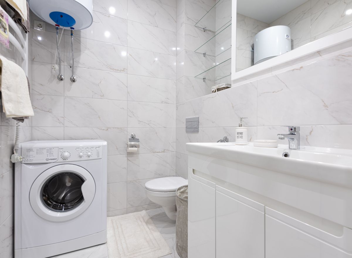 An all-in-one washer dryer combo in a minimalist small bathroom