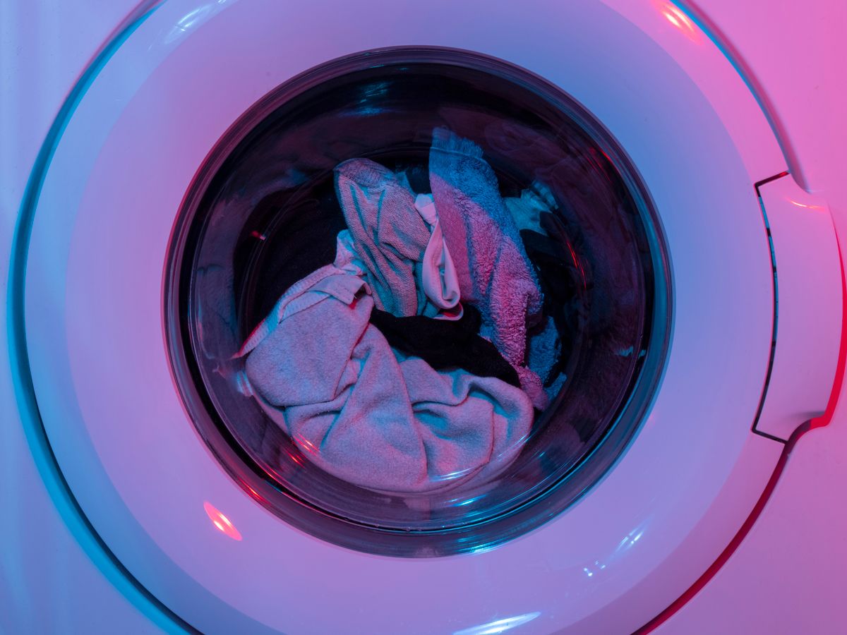 Clothes tumbling inside a washing machine at a set temperature