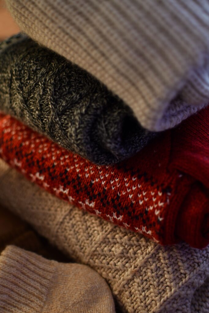 Cozy stack of winter knit sweaters